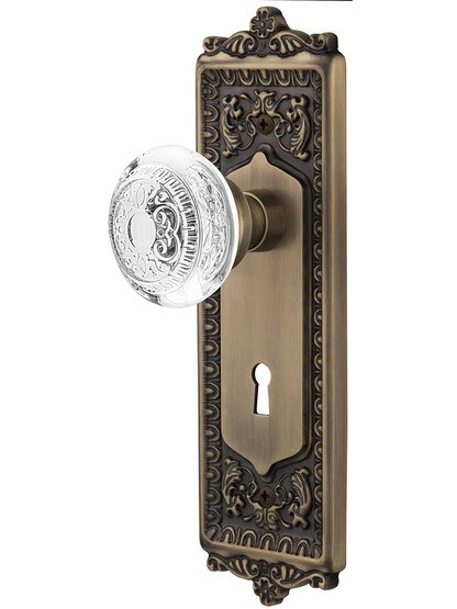 Egg and Dart Door Set with Keyhole and Matching Crystal-Glass Knobs in Antique Brass.